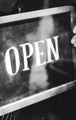 Man putting on shop open sign