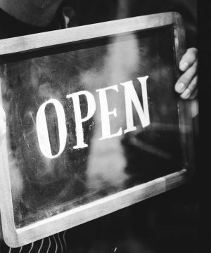 Man putting on shop open sign