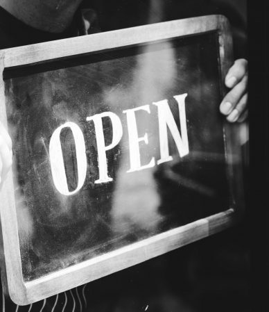Man putting on shop open sign